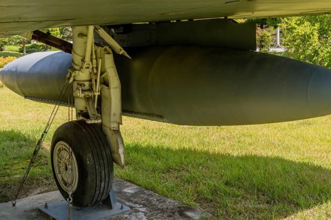 Closeup of starboard landing gear and external fuel tank on military fighter jet on display in