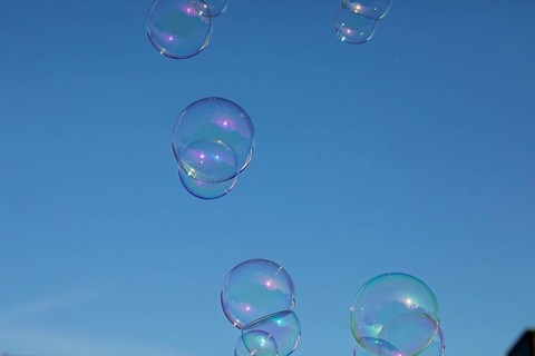Soap bubbles several coloured films of soapy water on top of each other in front of a blue sky