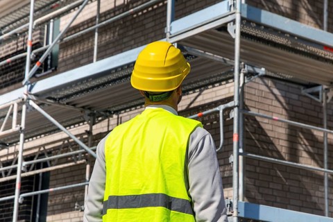 Symbolic image: Architect in front of an apartment block under construction