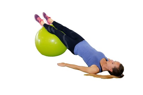 Symbolic image: Young woman doing exercises on an exercise ball against a white background