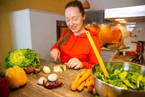 Vegan cooking: Young woman prepares lamb's lettuce