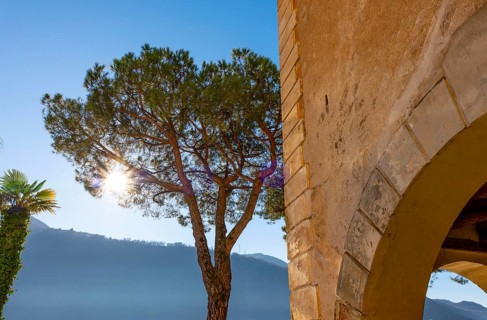 Old Beautiful Building and Trees on a Sunny Day with Blue Clear Sky and Mountain in Morcote,