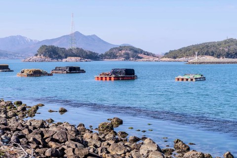 Floating docks loaded with fishing gear in water off island coastal seaport in Yeosu, South Korea,