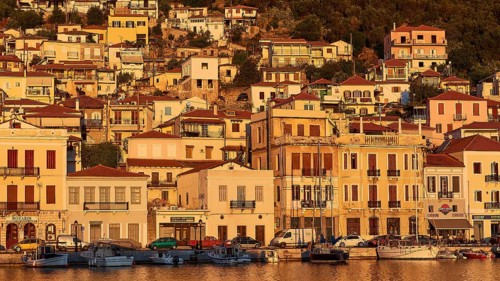 The warm colours of the evening sun shine on the traditional buildings and boats on the coast,