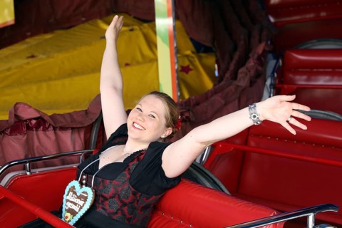 Cheerful woman travelling up and down the mountain at the Brezelfest in Speyer,