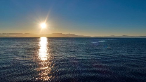 Sunrise over the sea with calm waves and clear sky, Gythio, Mani, Peloponnese, Greece, Europe