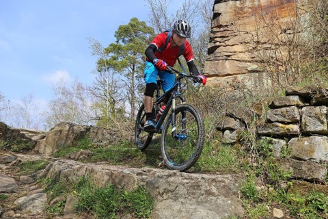 Mountain biker in difficult terrain in the Palatinate Forest near Wolfsburg