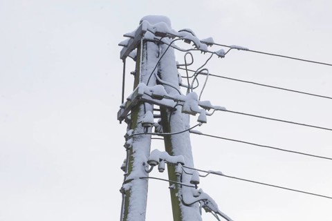 Old, snow-covered telegraph pole in winter, Germany, Europe