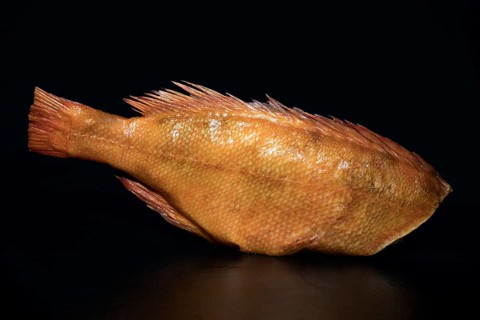 With skin, smoked redfish without head, food photography with black background