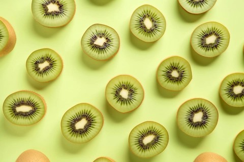 Top vie wof halv kiwi fruits on green background. KI generiert, generiert AI generated