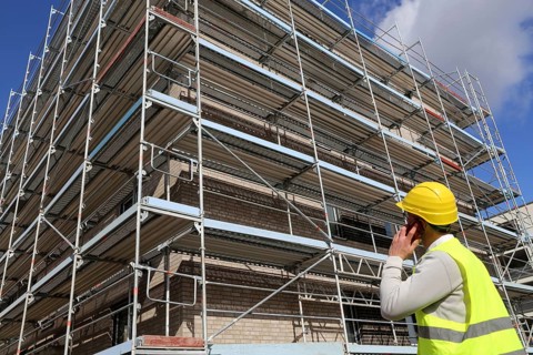 Symbolic image: Architect in front of an apartment block under construction