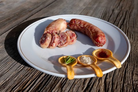 A Plate with Luganighe Sausage and with Species in Spoon Like Saffron and Parmesan Cheese and