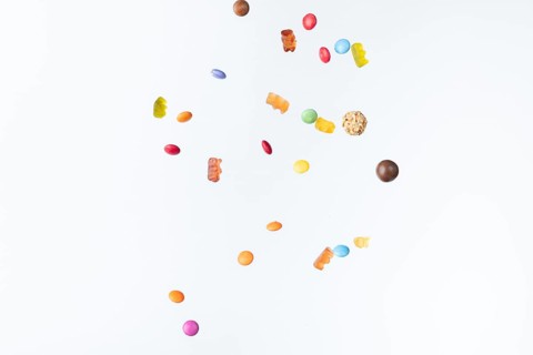 Colourful sweets fall against a white background