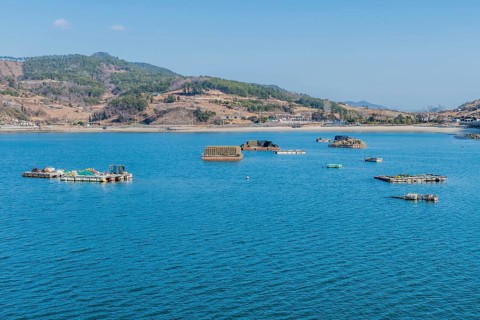 Floating docks loaded with fishing gear in water off island coastal seaport in Yeosu, South Korea,