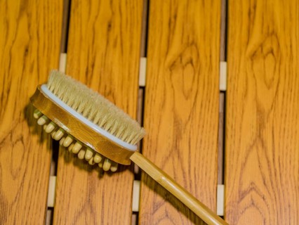 Bath and massage brush on wood grain background. Personal tool for massage spa and sauna accessory