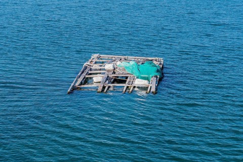 Dilapidated wooden raft held afloat with Styrofoam floats in ocean seaport in Yeosu, South Korea,