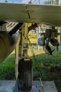 Rear view of landing gear and battery of missiles mounted under wing of military jet aircraft on