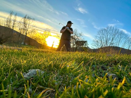 Golfer in a Sand Trap on Golf Course in Sunset in a Sunny Day in Switzerland
