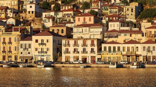 Houses and boats on the coast in the golden light of early morning, Gythio, Mani, Peloponnese,