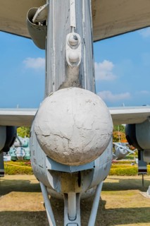 Rear view of ventrally-mounted retractable radar boom on military airplane in public park