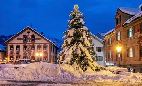 Snow-covered Christmas tree on the historic Ludwigstrasse in the Partenkirchen district at dusk,