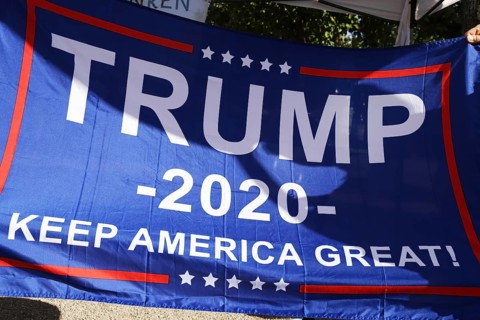 Convinced Trump supporters in Germany hold up a banner with the campaign slogan Trump 2020 - keep