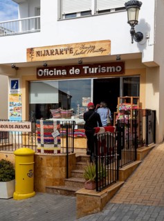 People entering the Oficina de Turismo tourist information shop and office, village of Nijar,