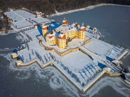 Moritzburg Castle on the castle island surrounded by the frozen castle pond, Moritzburg, Saxony,