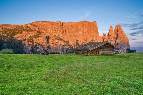 Alpine hut in front of Schlern, sunrise, blue sky with clouds, Seiser Alm, Dolomites, South Tyrol