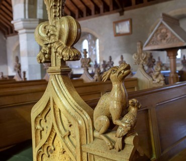 Carved pew bench ends inside All Saints church, Hollesley, Suffolk, England, UK