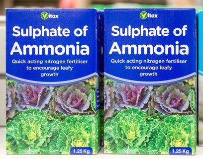 Cardboard boxes of Vitax Sulphate of Ammonia on shelf display in garden centre, UK