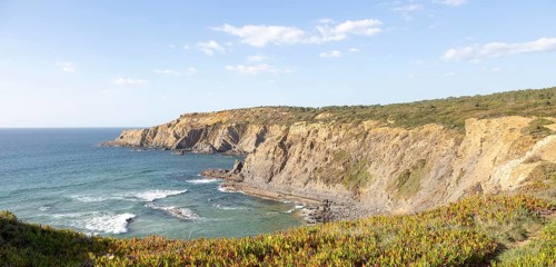 Rocky coastal landscape Praia dos Alteirinhos beach in bay with rocky headland part of Parque