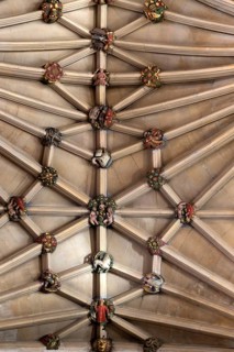 Vaulted stone roof ceiling showing painted roof bosses, Norwich Cathedral, Norfolk, England, UK