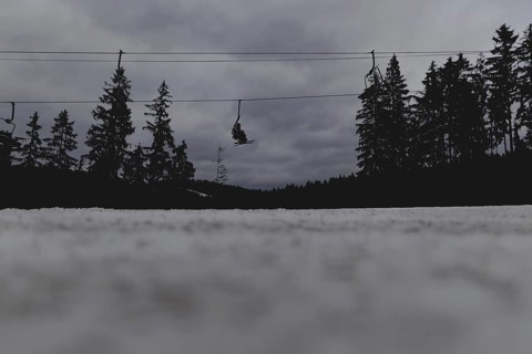Skiers ride a chairlift, taken on a ski slope in the Jizera Mountains ski area near Albrechtice v