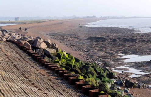 Land protected by rock armour coastal defences, Bawdsey, Suffolk, England, UK low tide reveals