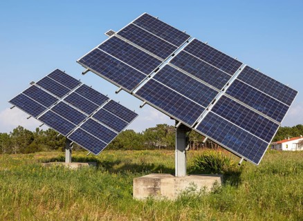 Solar panel array in rural location of field in countryside providing domestic energy near village