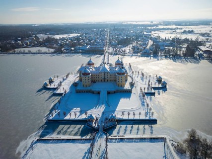 Moritzburg Castle on the castle island surrounded by the frozen castle pond, Moritzburg, Saxony,