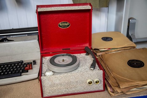 A Dansette Popular mono portable record player on sale at auction next to 78 rpm records