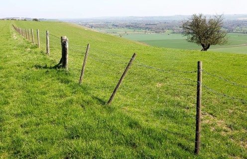 Fence running along top of chalk scarp slope looking south east over Vale of Pewsey, near Knap