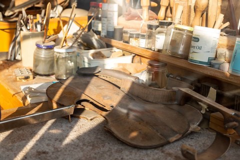 Workbench seen through shop window of the Violin Shop, Market Hill, Woodbridge, Suffolk, England,
