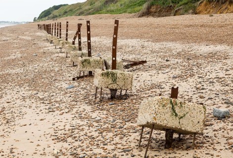 Remains of steel stanchions for barbed wire anti-invasion defences on beach at Bawdsey, Suffolk,