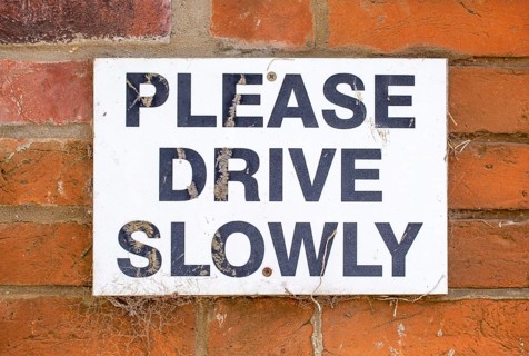 Macro close up sign Please Drive Slowly, UK