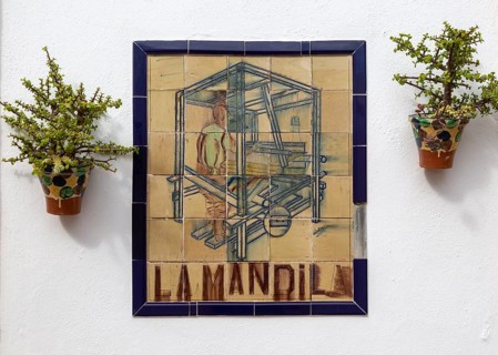 Close up of ceramic tile sign for textile workshop outside bar restaurant, Nijar, Almeria, Spain,