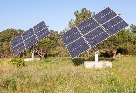 Solar panel array in rural location of field in countryside providing domestic energy near village