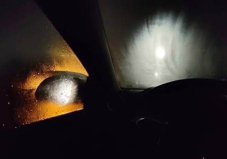 View from the car in dangerously poor visibility at night with rain and blinding backlight,
