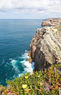 Sheer cliffs rise from Atlantic Ocean at Cabo de Sao Vicente, Cape St Vincent, Algarve, Portugal