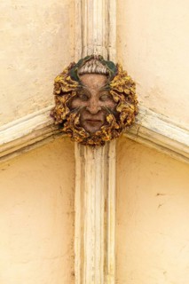 Roof boss face of green or wild man in cloisters, Norwich Cathedral, Norfolk, England, UK