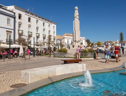 People sitting in sunshine outside street cafes in Praca da Republica, Tavira, Algarve, Portugal,