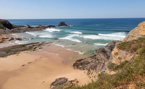 Sandy Carvalhal beach in bay between rocky headlands at Parque Natural do Sudoeste Alentejano e