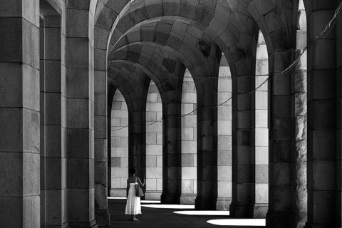 Lady in a white dress in the arcade of the Congress Hall, unfinished National Socialist monumental